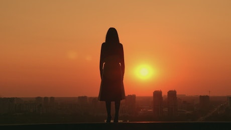 Woman during a sunset on a rooftop.