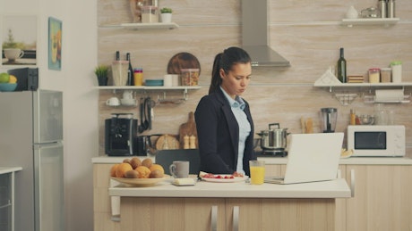 Woman eating breakfast while working.