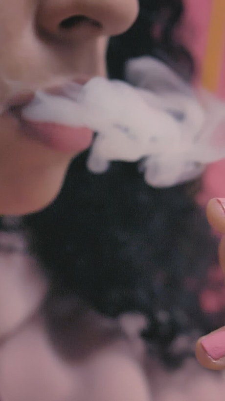 Woman exhaling marijuana smoke
