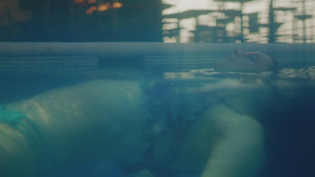 Woman floating in pool.