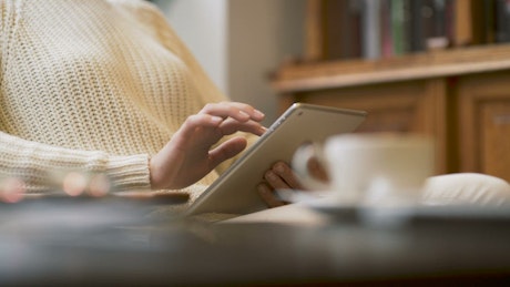 Woman holding a tablet device at home.