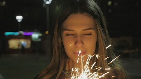 Woman holding two sparklers.