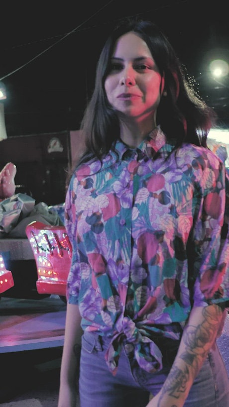 Woman in a floral shirt dancing.