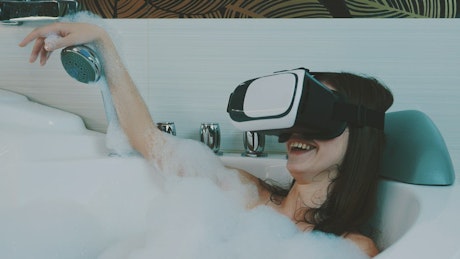 Woman in the bath laughing in VR