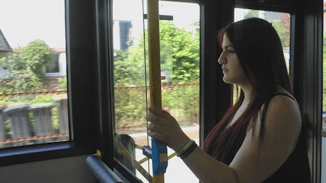 Woman in the bus seeing through the windows