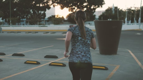 Woman jogging through parking lot