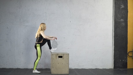 Woman jumping on a box.