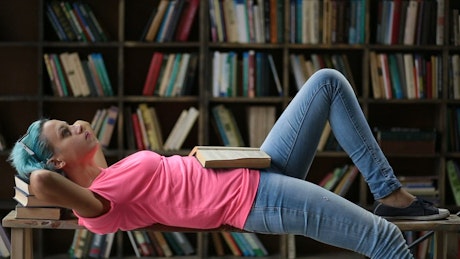 Woman laying down with her books.