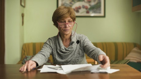 Woman looking stressed as she does paperwork.