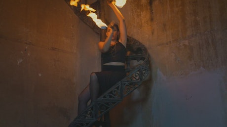 Woman making an artistic dance with fireballs.