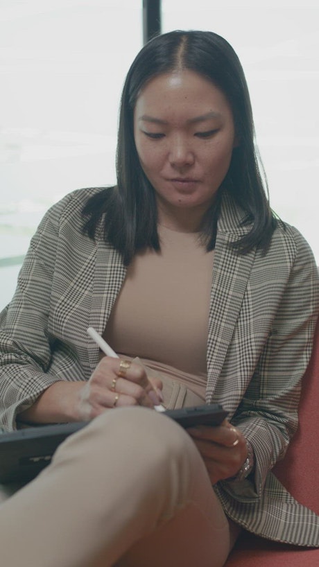 Woman making notes on a tablet with a stylus.