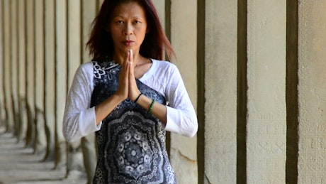 Woman meditating outside of a Buddhist temple.