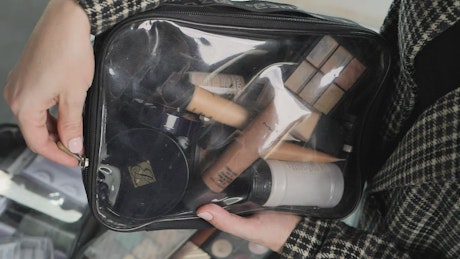 Woman opening a bag with makeup
