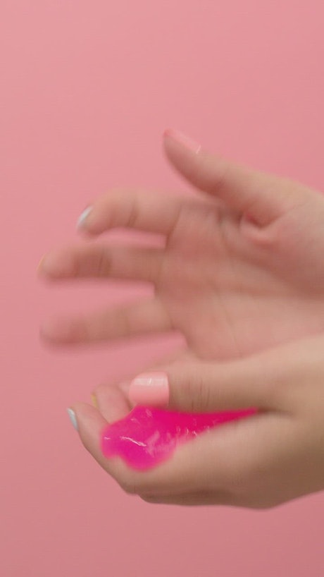 Woman playing with Pink slime with her hands.