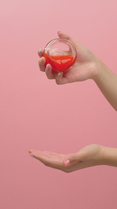 Woman playing with slippery red slime with a bowl.