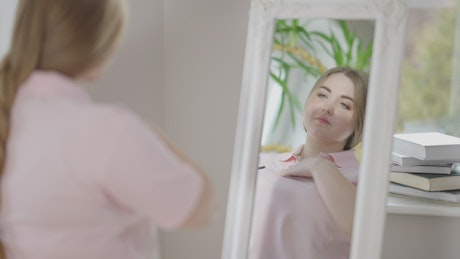 Woman posing in front of a mirror before she goes to work.
