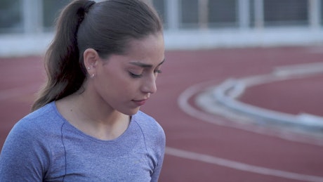 Woman preparing to run on a track.