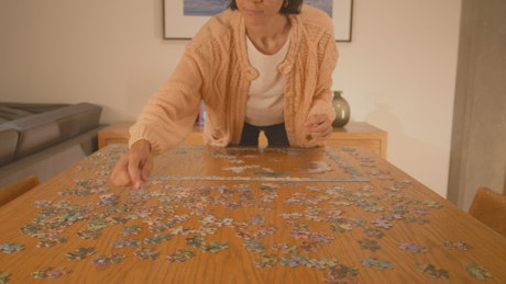 Woman putting together a puzzle of many pieces.
