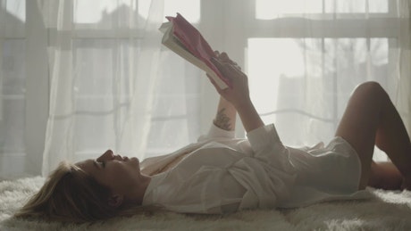 Woman reading a story lying on the bed.