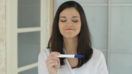 Woman rejoices after seeing her pregnancy test.