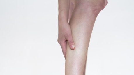 Woman rubbing a sore muscle in her leg.