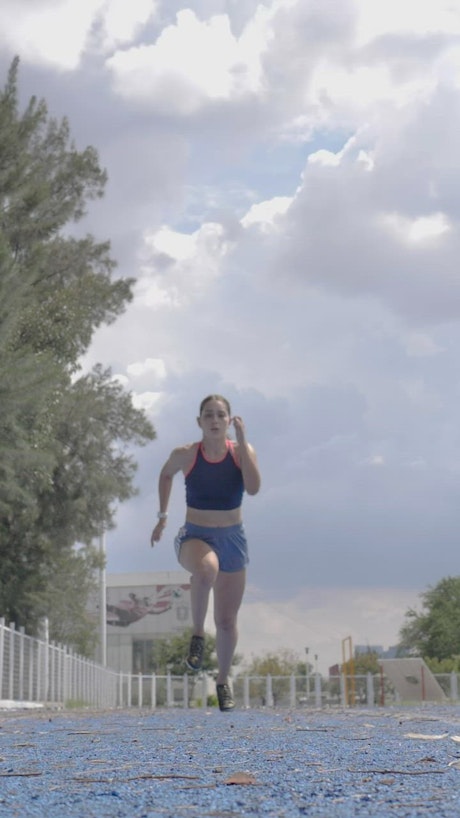 Woman running above the camera on a running track