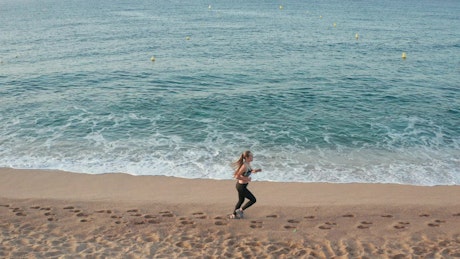 Woman running by shallow waves
