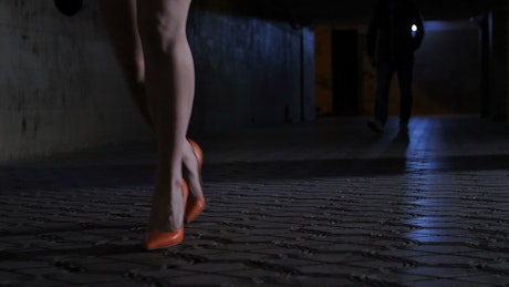 Woman running from someone at night.
