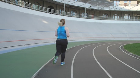 Woman running on a running track.