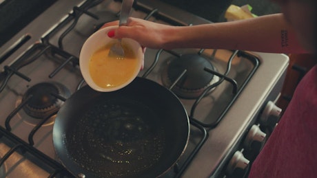Woman serving eggs in a pan for breakfast.