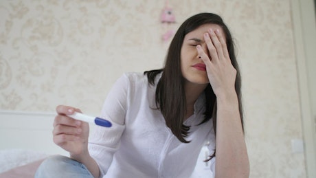Woman shocked with her pregnancy test.