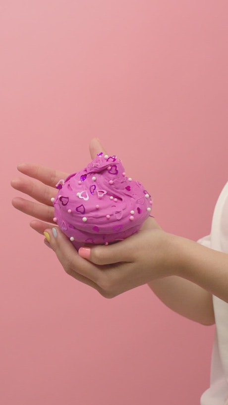 Woman showing pink ice cream shaped plasticine.