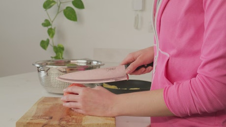 Woman slicing a peach for fruit salad.