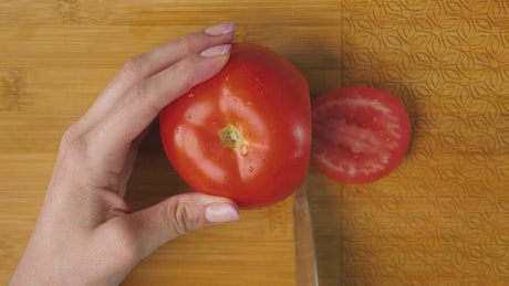 女人在木板上切西红柿