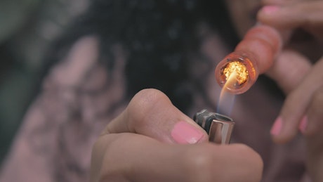 Woman smokes marijuana with a glass pipe