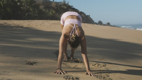 Woman stretching and doing yoga on the beach