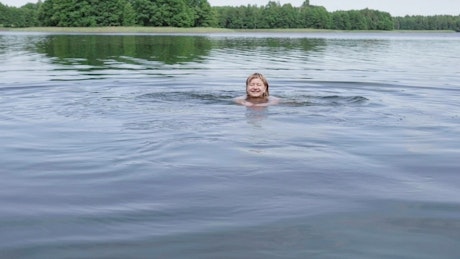 Woman swimming across a lake