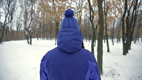 Woman taking a walk in the winter forest