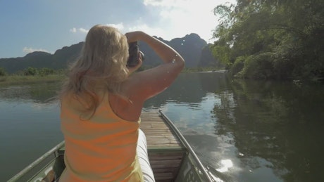 Woman taking photos during a boat tour.