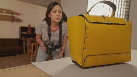 Woman taking pictures out of a yellow bag.