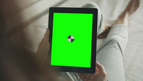 Woman touches tablet with chroma key greenscreen