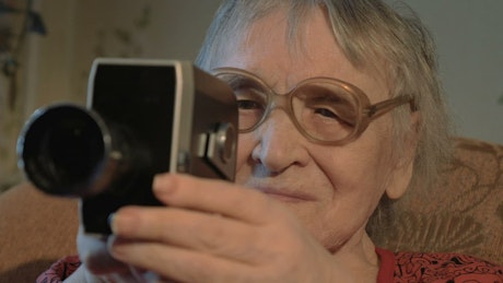 Woman using a retro camera inside