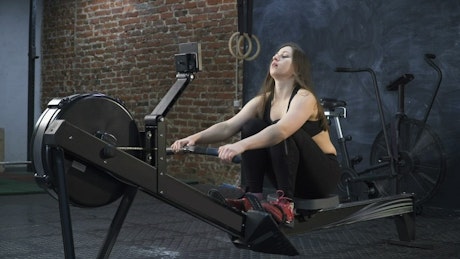Woman using a rowing machine.