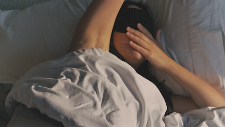 Woman waking up peacefully taking off her mask