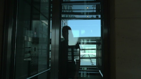 Woman walking out of an elevator.
