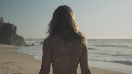 Woman walks and twirls on the beach