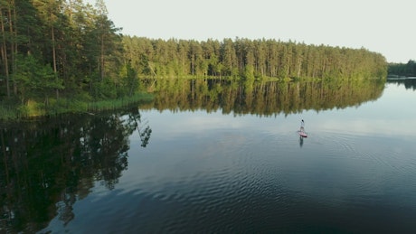 Woman wandering in nature on a paddleboard.