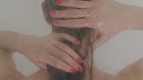 Woman washing her hair while taking a bath.