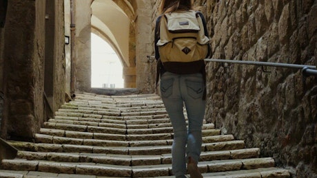 Woman with a backpack walking up the stairs