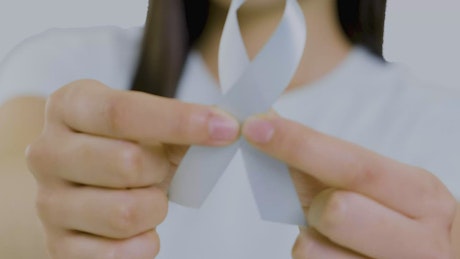 Woman with a lung cancer ribbon on her chest.